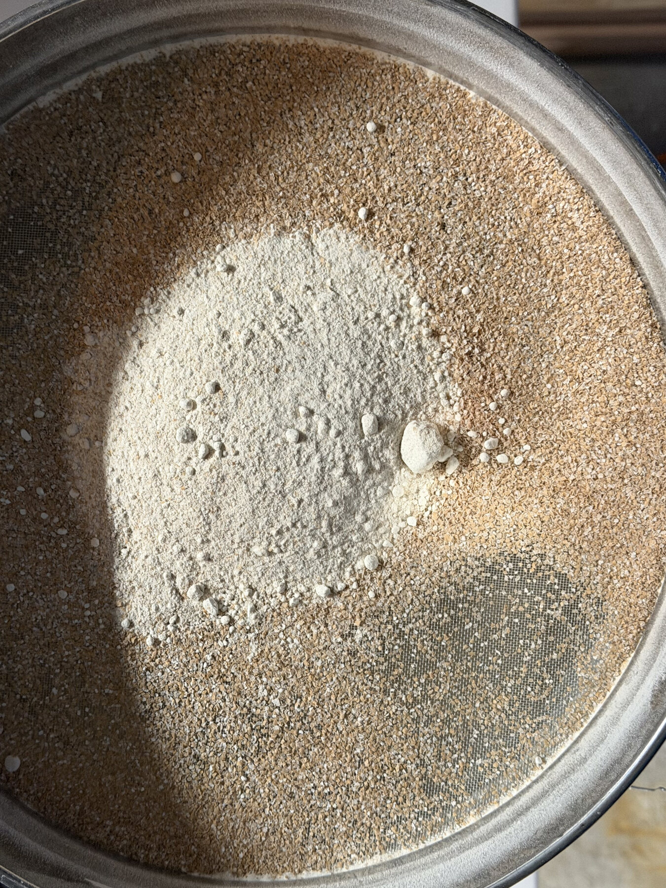Freshly milled flour and grain in a round sifter
